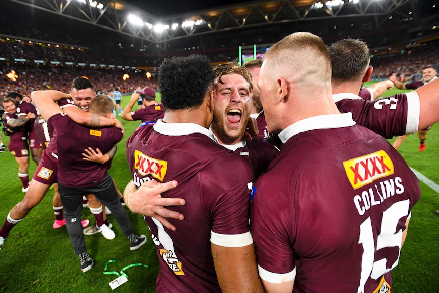 Queensland Maroons stars Cameron Munster, Felise Kaufusi and Lindsay Collins embrace in joy after 2020 State of Origin series.