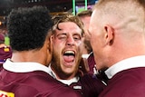 Queensland Maroons stars Cameron Munster, Felise Kaufusi and Lindsay Collins embrace in joy after 2020 State of Origin series.