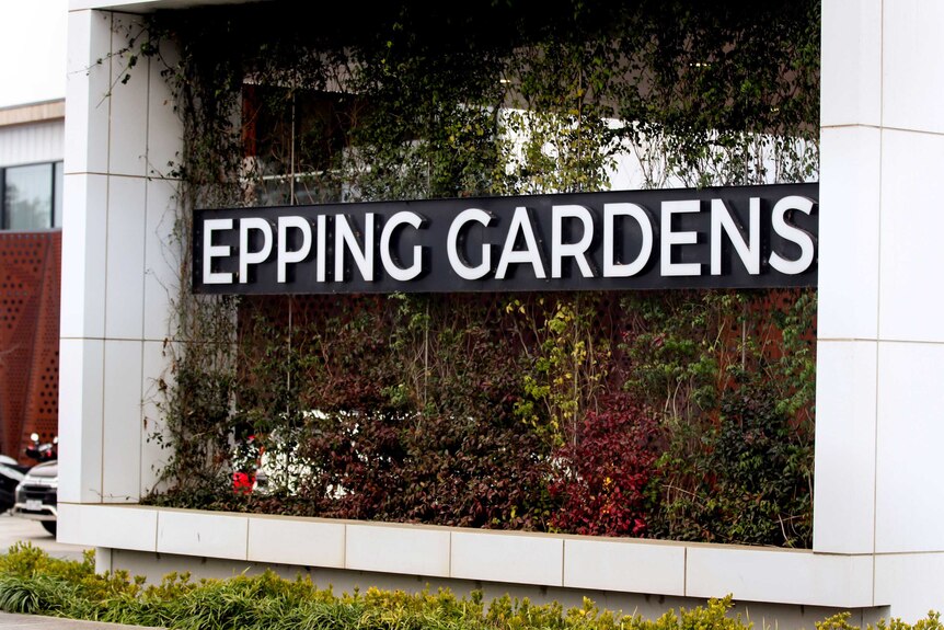 Large Epping Gardens sign on vertical garden wall with white tiles on either side