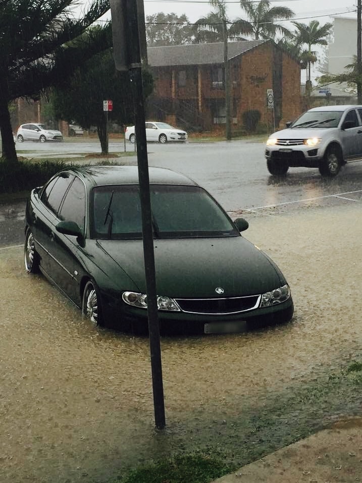 A car partially submerged in floodwater on a suburban street in Woolgoolga on the Mid North Coast of NSW.