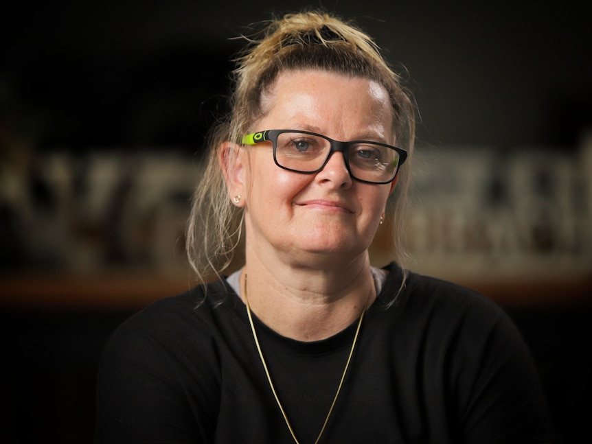  Close up of woman wearing black glasses and black top looking at camera