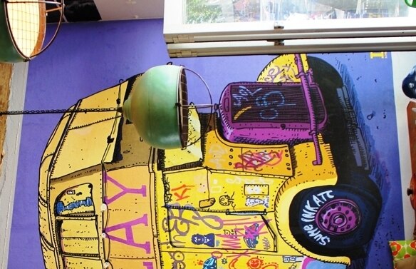 Street art of a colourful bus inside a cafe on an internal wall