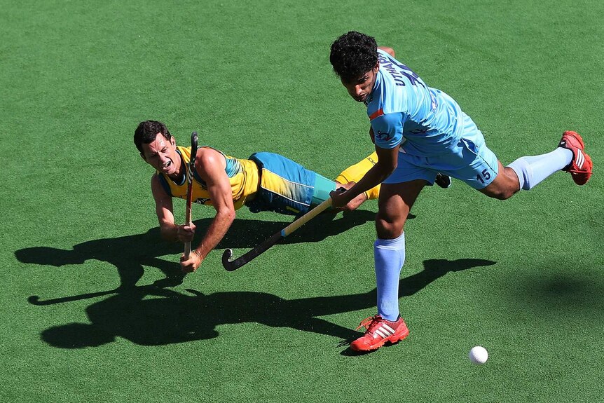 Australia's Jamie Dwyer hits the ball past India's Sushant Tirkey in the Champions Trophy semifinal.
