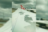 Lots of gaffer tape is stuck to an airplane wing.