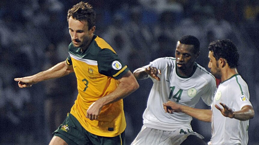 Australian striker Josh Kennedy takes on the Saudi defenders