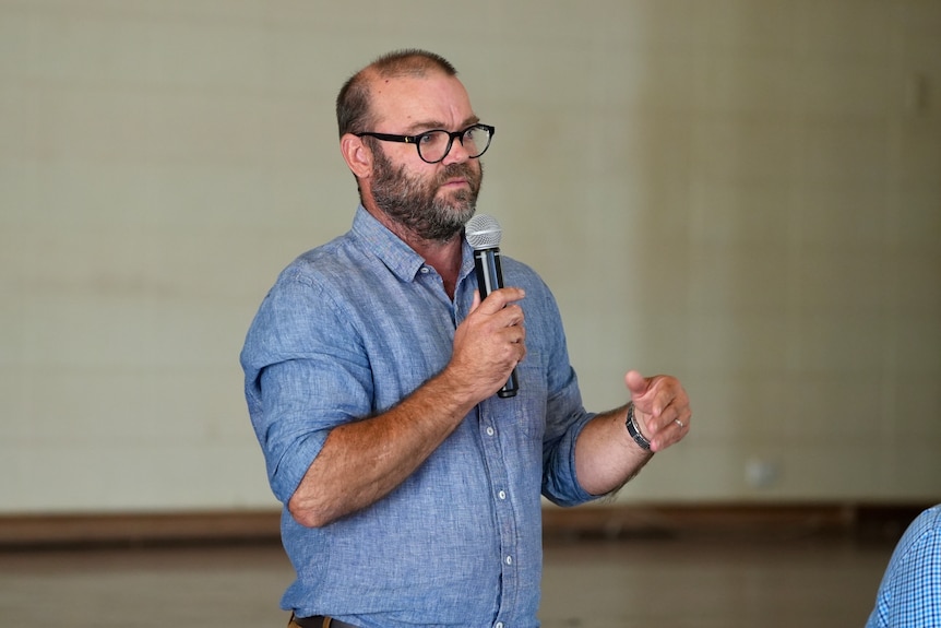 A man standing holding a microphone