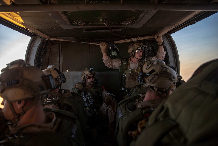 Military personnel in a military aircraft.