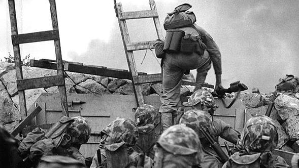 Black and white image of soldiers climbing a ladder