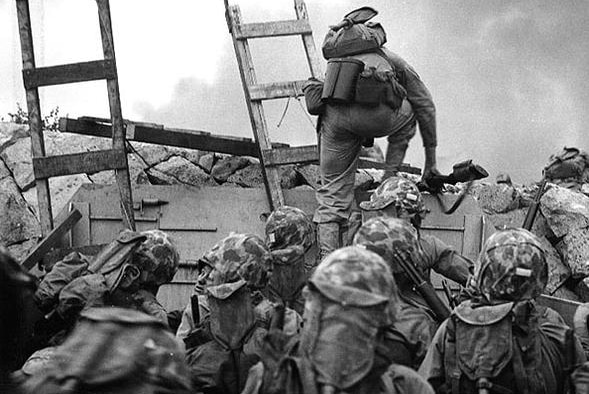 Black and white image of soldiers climbing a ladder