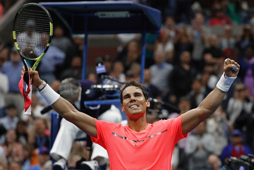 Rafael Nadal raises his arms with a smile on his face after beating Andrey Rublev.