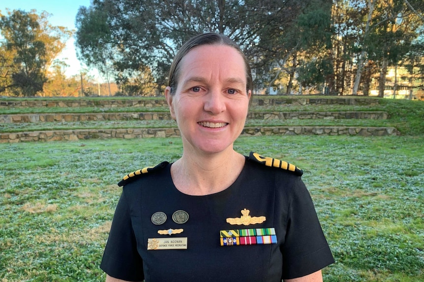 A middle-aged woman in military dress smiles for the camera.