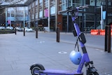 An electric scooter stands with nobody in sight.