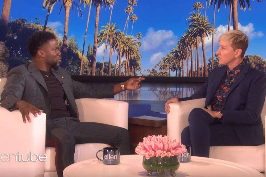 Kevin Hart sitting with Ellen DeGeneres on the set of her television show.