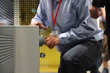 Man kneeling on floor with his hand on a security safe.