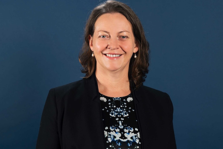 A professional profile photo of professor McKetin, wearing a black suit jacket and black and blue top.