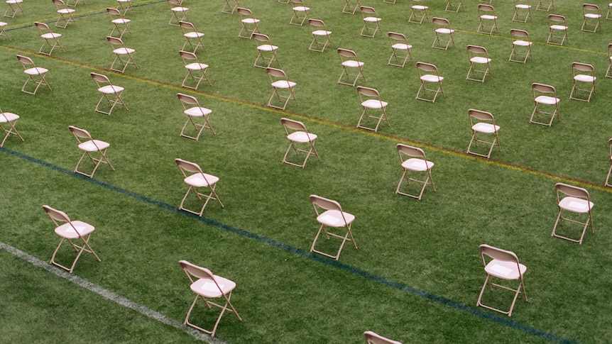 A photo of dozens of deck chairs spaced out on a grassy field