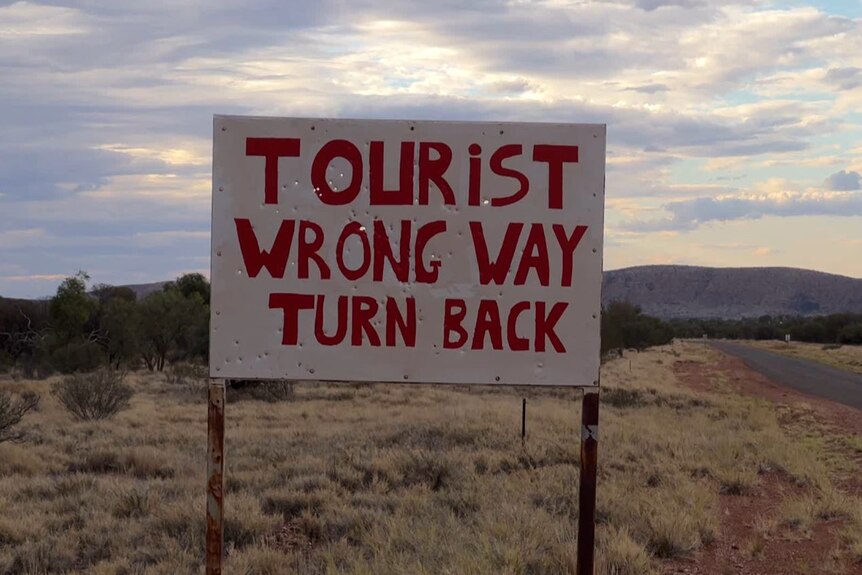 A sign says 'Tourist wrong way turn back'