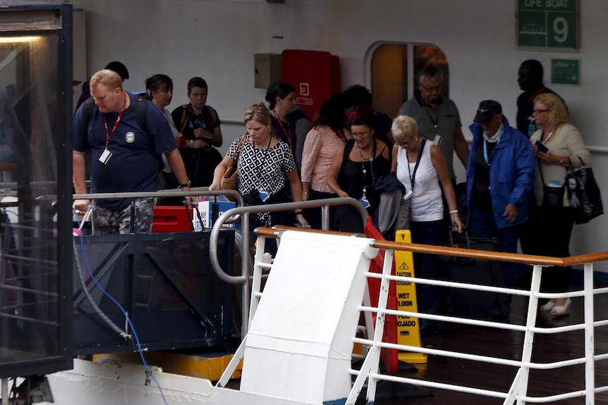 Passengers disembark from a cruise ship.