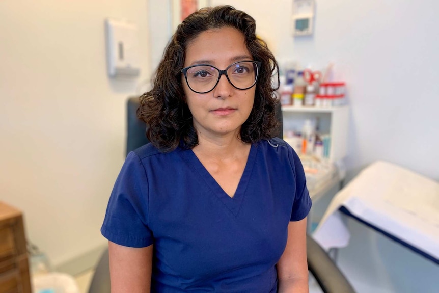 Neela Janakiramanan is pictured in a medical consulting room, with a serious expression on her face.