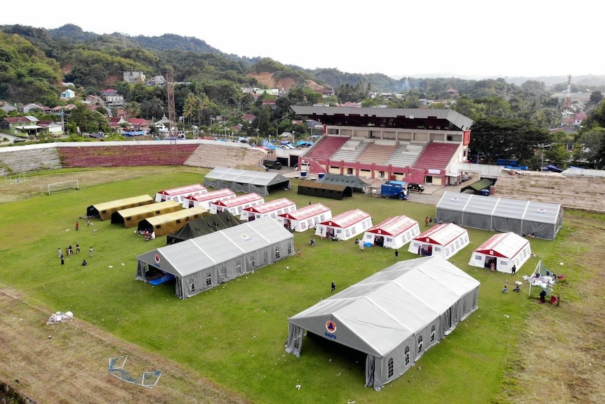 An aerial view of makeshift tents on a sports field.