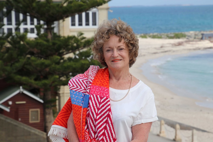 Sandra Boulter with a towel over her shoulder and Cottesloe beach in background.