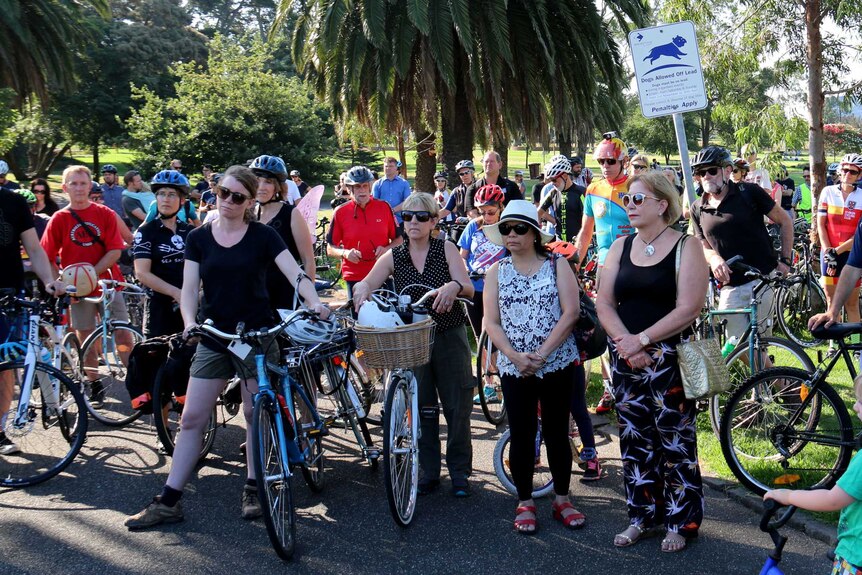Group of people with bicycles attending a memorial service in Yarraville