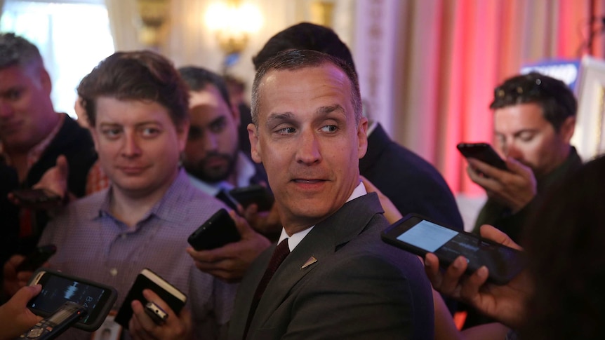 Corey Lewandowski surrounded by journalists.