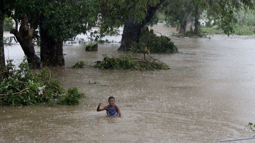 A person wades through floodwaters caused by Cyclone Winston in Fiji.