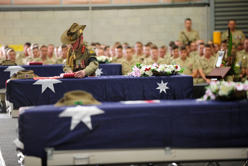 Chief of Army Lieutenant General David Morrison, AO places medals on Captain Bryce Duffy's casket.