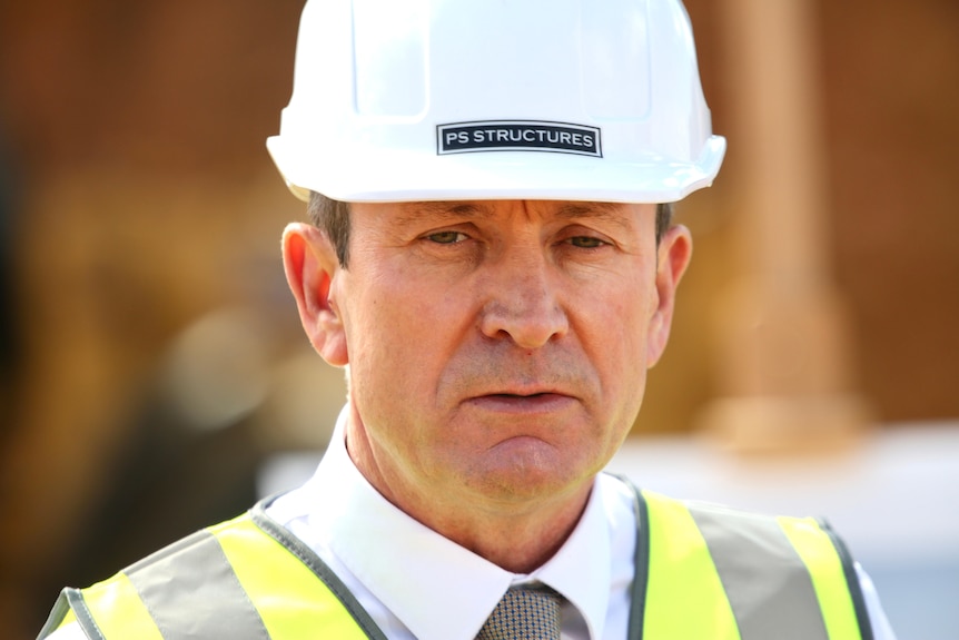 A close-up shot of WA Premier Mark McGowan speaking while wearing a hard hat and hi-vis vest.