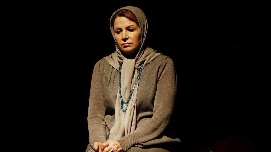 An actor in the play Manus sits on jerry cans.