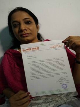 Arshia Ismail holds up a certificate