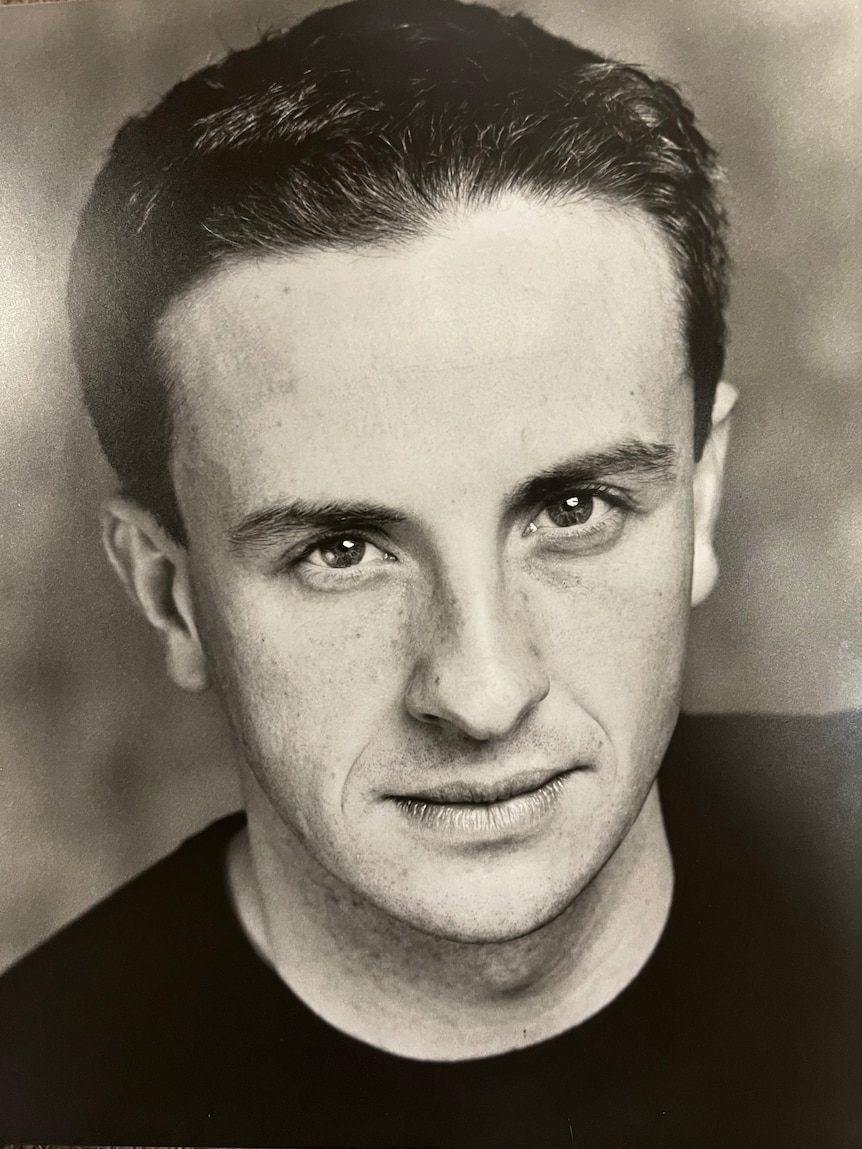 A black and white photo of a man with short dark hair