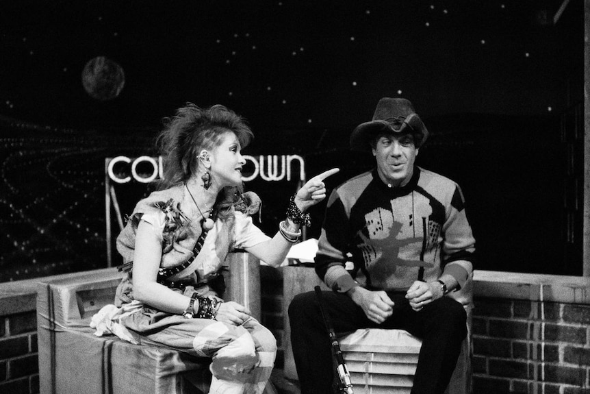 Cindi Lauper (left) points to host Molly Meldrum (right) on the Countdown set.