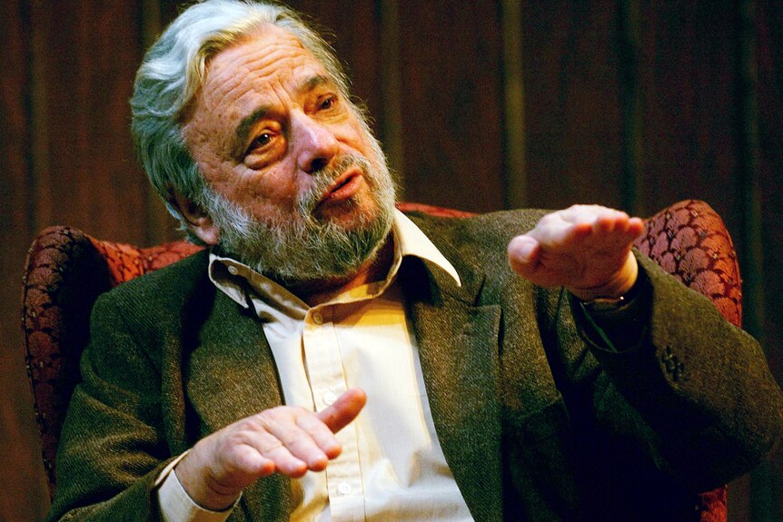 Stephen Sondheim holds both hands in front of him, palms flat down