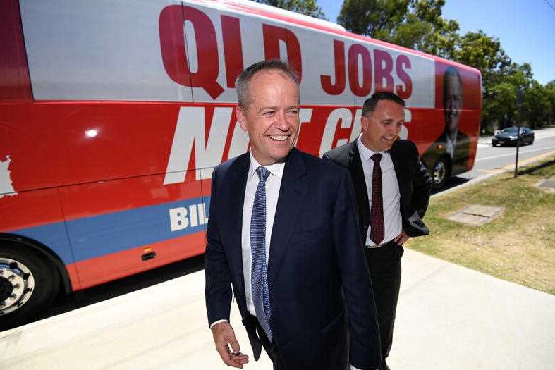 Bill shorten stands next to his campaign bus