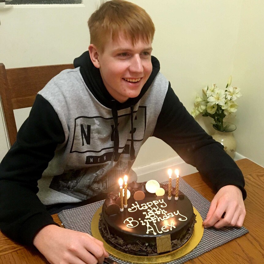 Alex Braes smiles with his 18th birthday cake