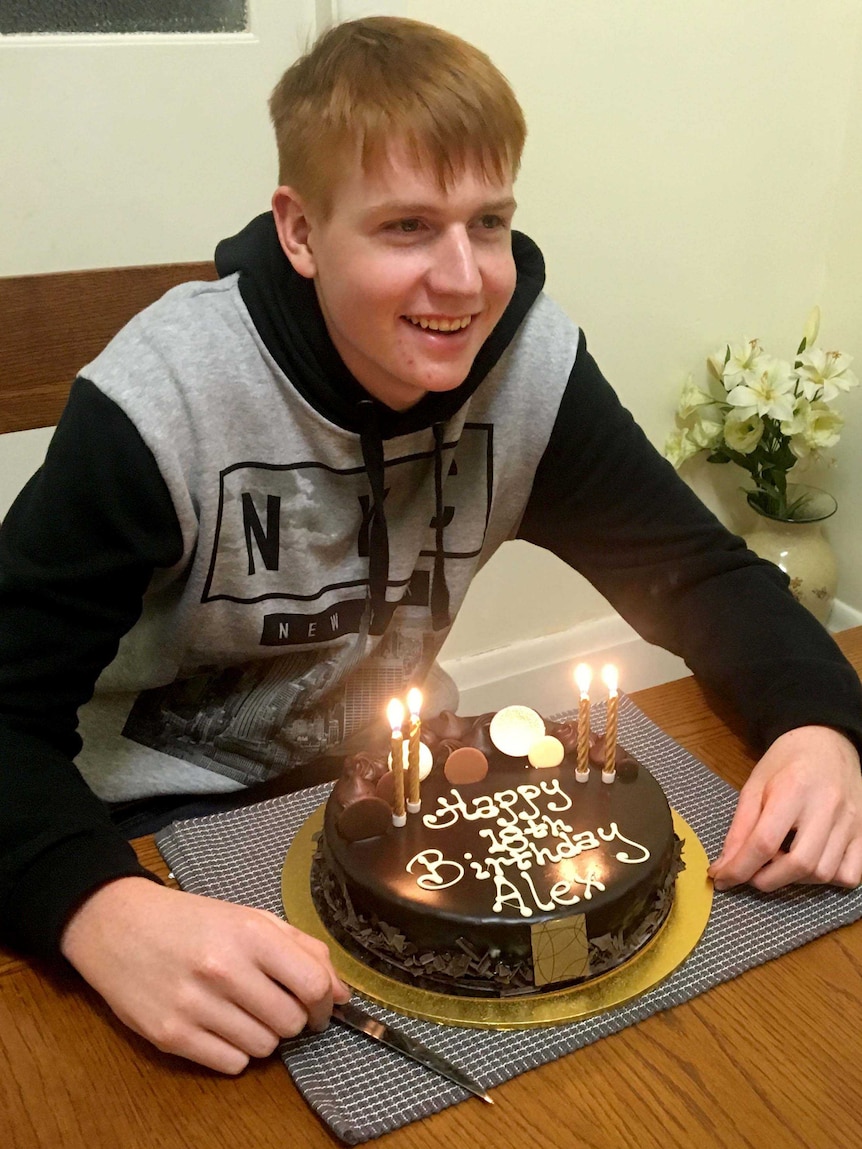 Alex Braes smiles with his 18th birthday cake