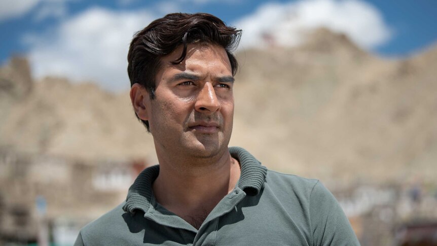 Ashiq Razaqi stands infront of mountains