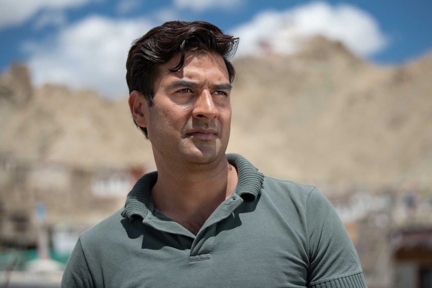 Ashiq Razaqi stands infront of mountains