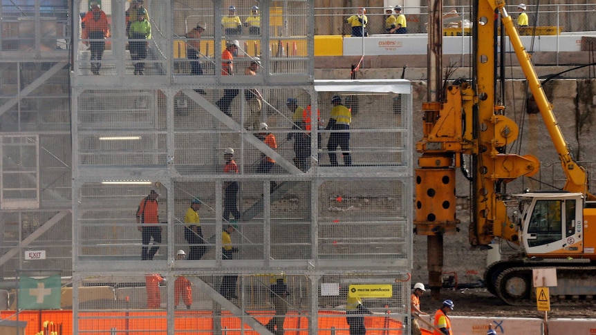 Construction workers descend using temporary stairs on a major construction site in central Sydney