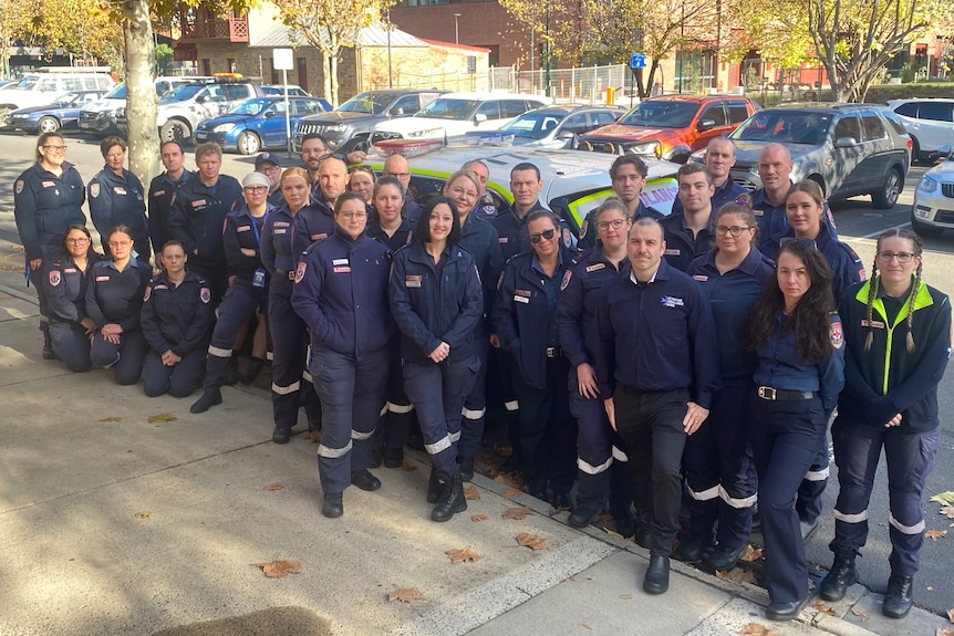 A group of paramedics standing outside on-street car parking, in front of the new Bendigo Law Courts.