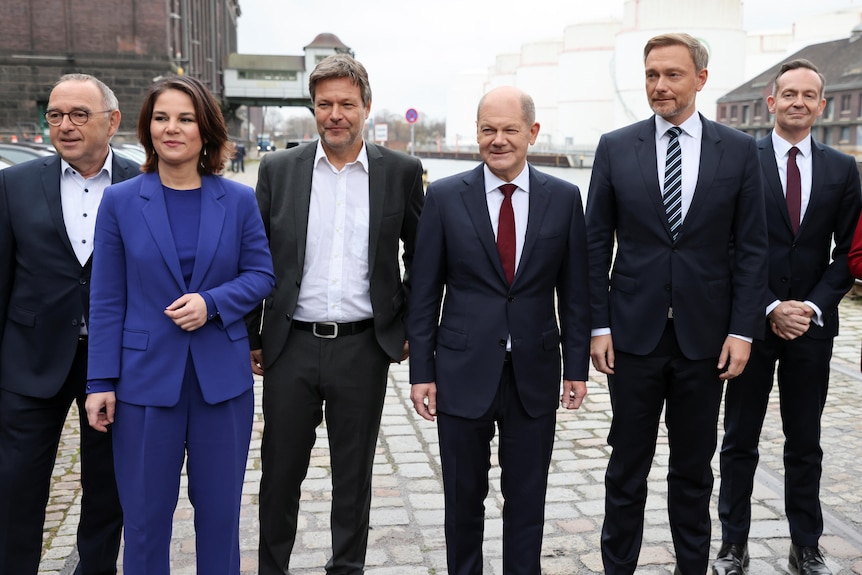 Six German politicians, five men and one woman, pose for a photo after coalition talks.