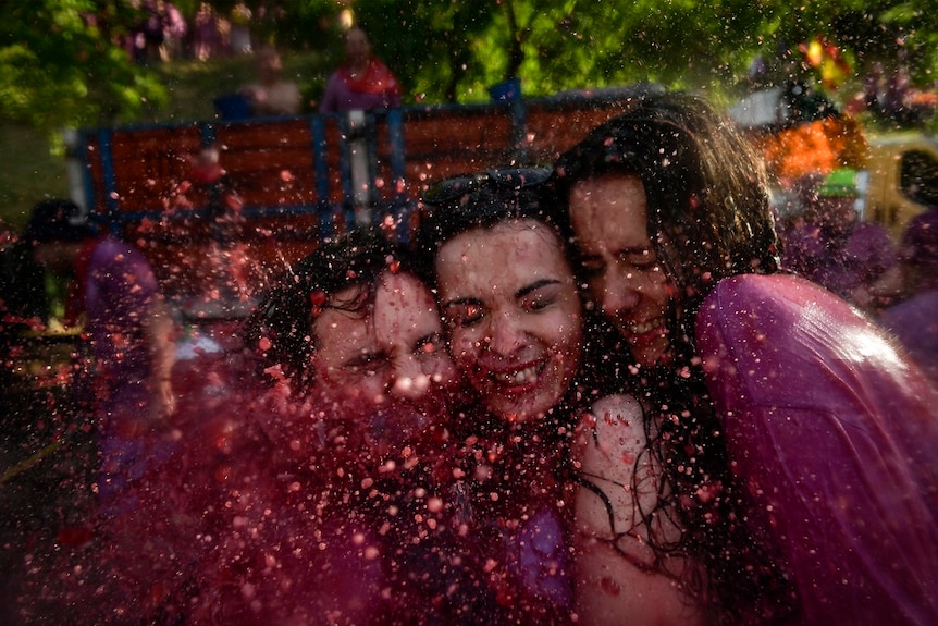 Revellers smile while taking part in a wine battle, in the small village of Haro, northern Spain, Saturday, June 29, 2019.