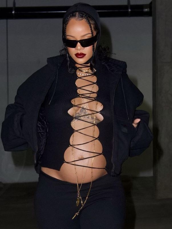 Rihanna wearing a black outfit showing off her pregnant stomach