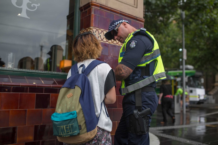 A pedestrian is spoken to by a Victoria Police officer in Melbourne after being spotted jay walking in the city.