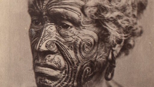 A sepia photo of an unknown Maori man with a tattooed face, circa late 1800s.