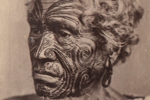 A sepia photo of an unknown Maori man with a tattooed face, circa late 1800s.
