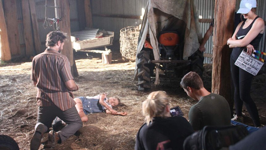 Actors Daniel Potts and Summer Robertson in a barn in a scene from the film Jade.