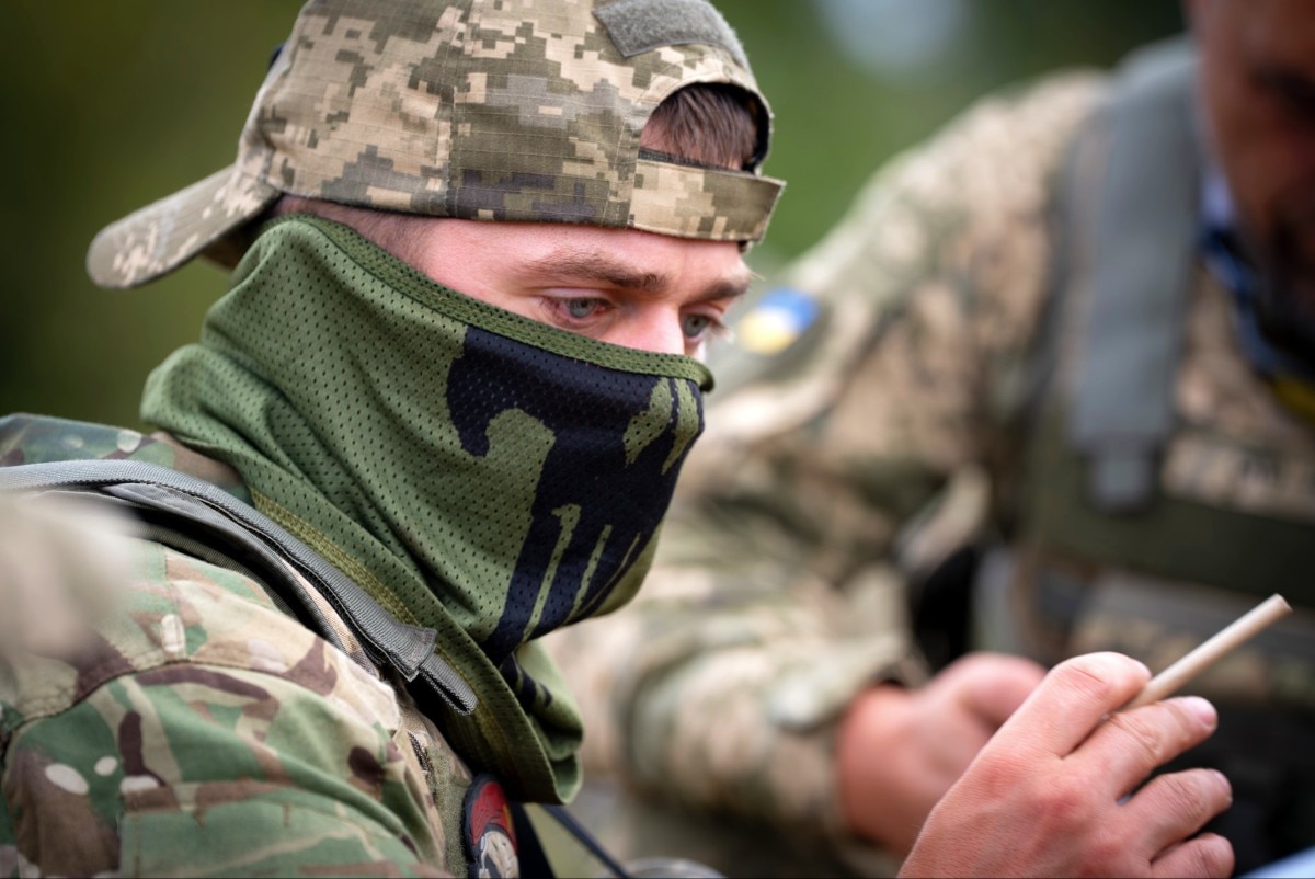 A soldier looking at a pencil in their hand.